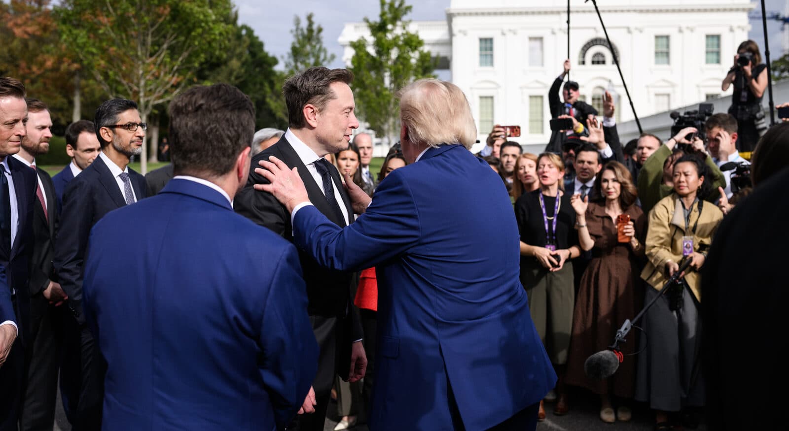 Donald Trump puts a hand on a tech executive's shoulder outside the West Wing, with the White House behind them, after the lunch on September 29, 2026.